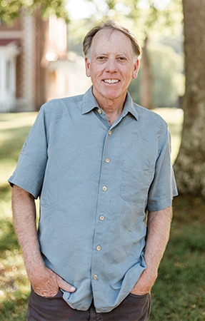 A photo of Dr. Reynolds outdoors, smiling beneath a tree.